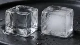 Dois cubos de gelo caseiro, um mais transparente e outro com centro branco e turvo.