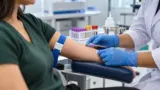 Profissional de saúde coleta sangue do braço de uma pessoa em laboratório